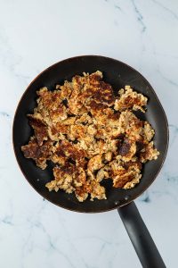 Pfanne mit zerkleinertem Haferflocken-Kaiserschmarrn.