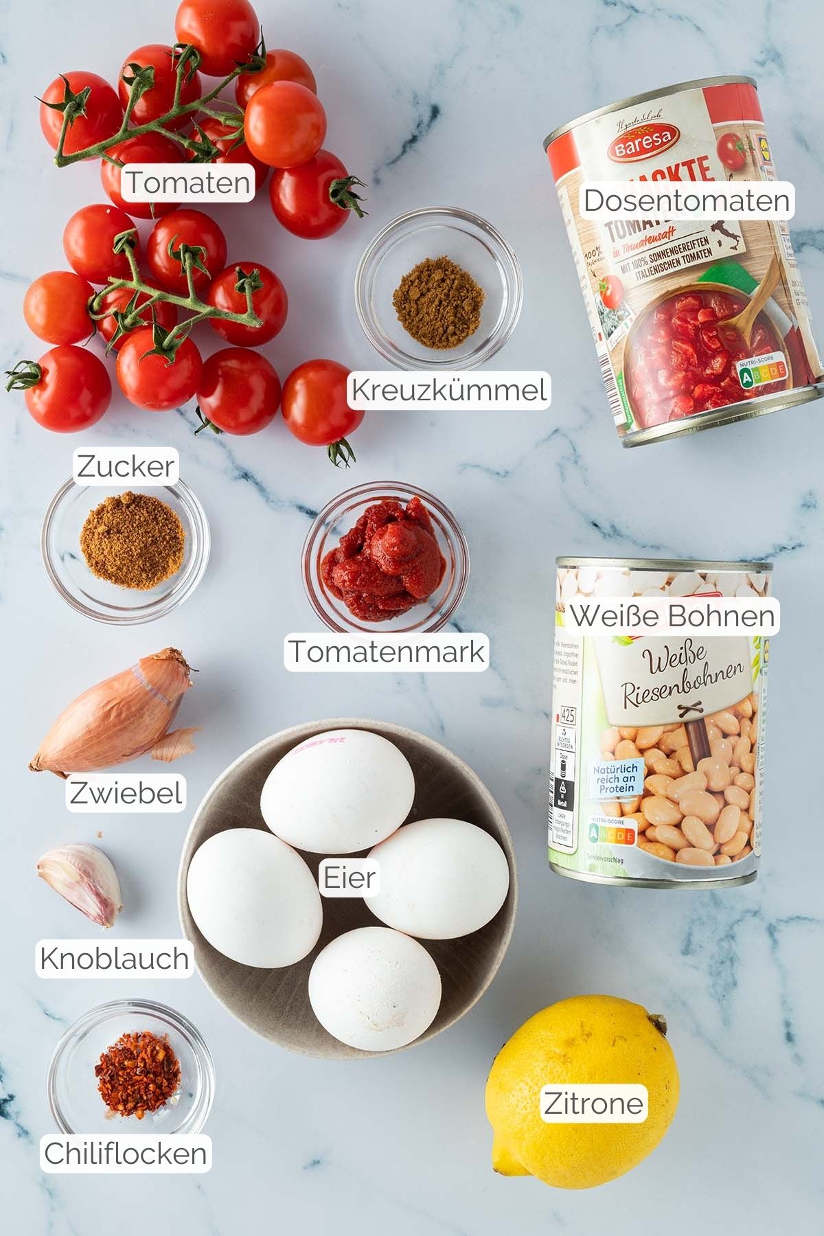 Foto aller Zutaten mit jeweiligen Textbeschriftungen, die f&uuml;r das Shakshuka mit Bohnen ben&ouml;tigt werden.