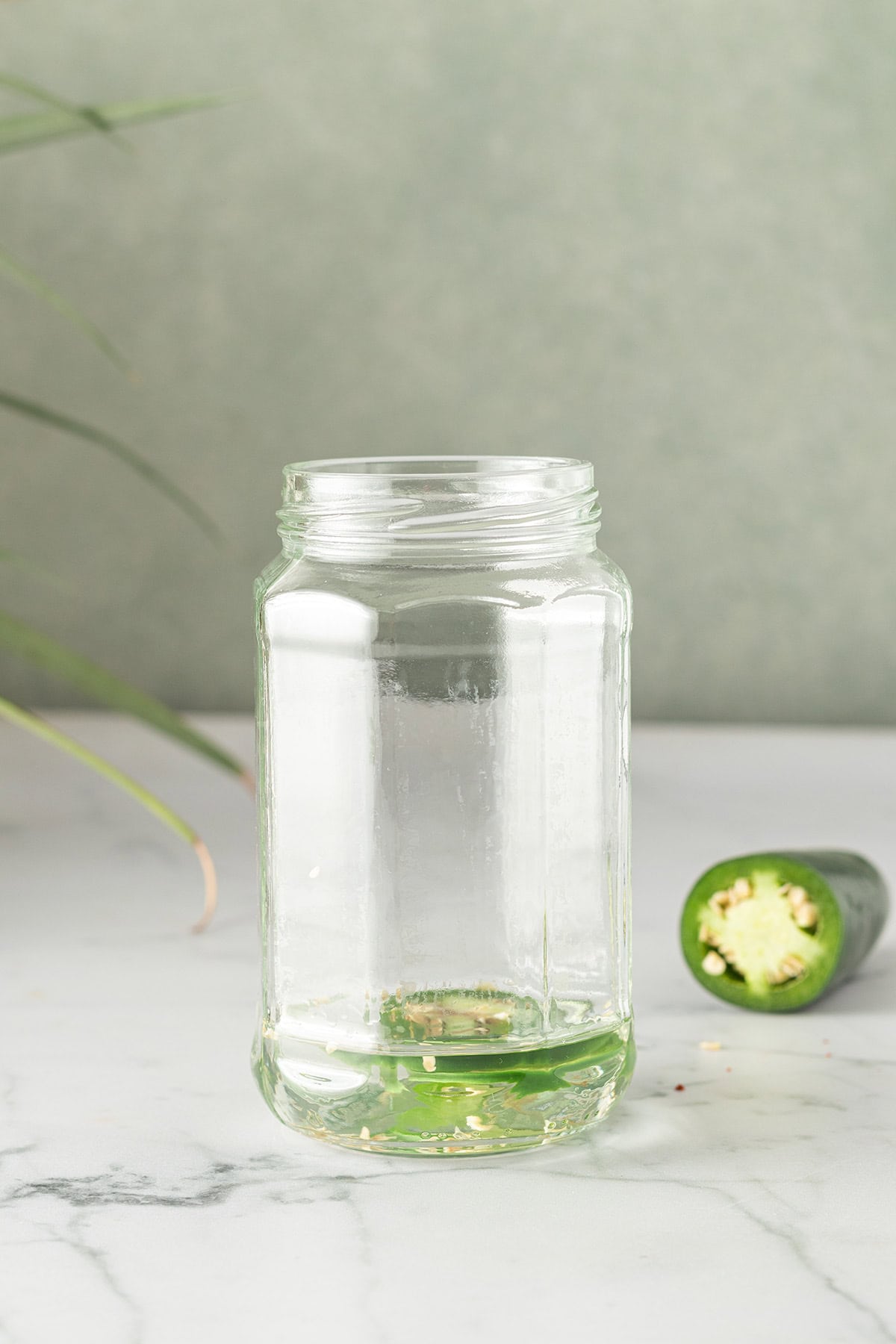 Tequila und zwei Scheiben Jalape&ntilde;o in einem Schraubglas.