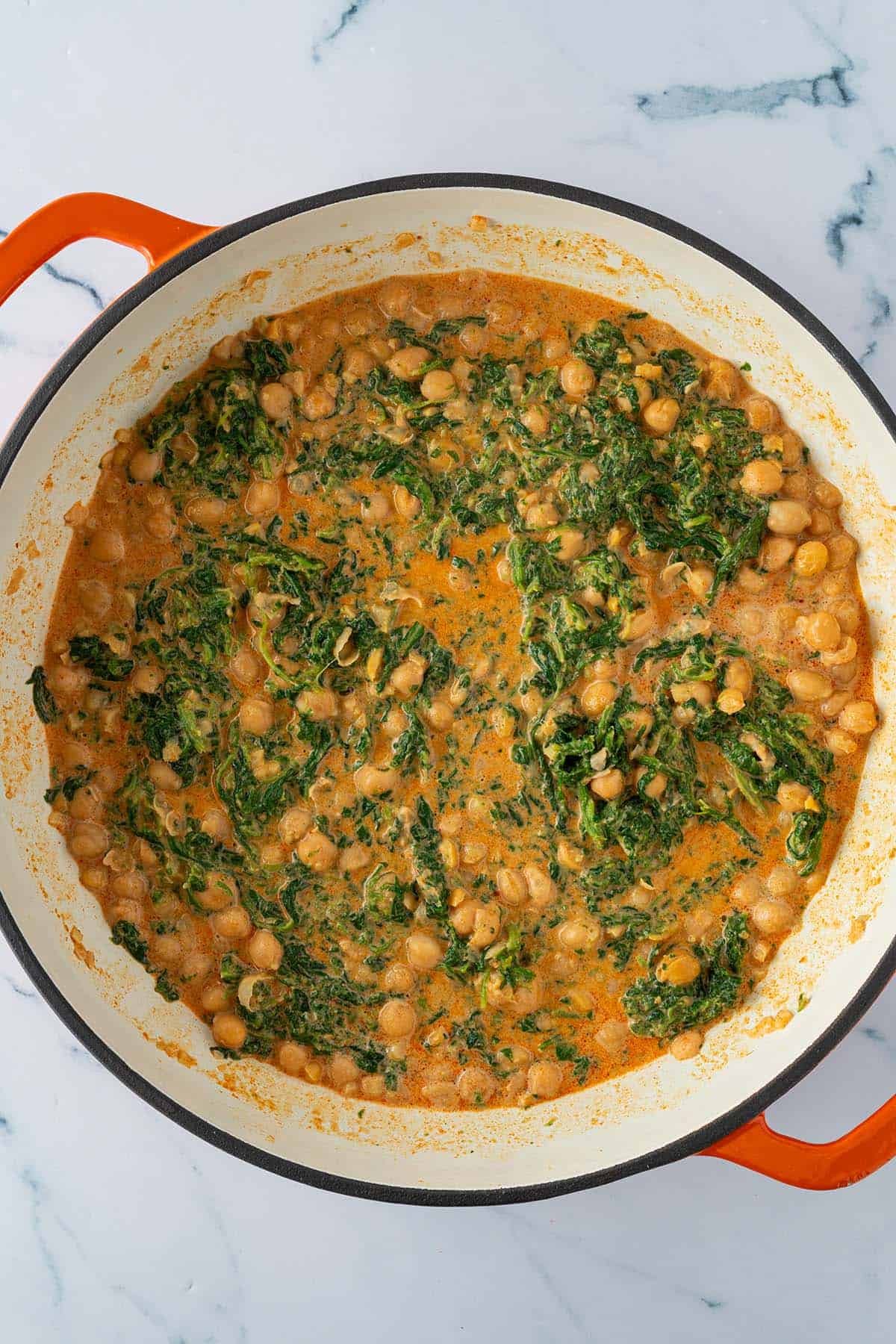 Fertiges Kichererbsen Curry mit Blattspinat in der Pfanne.