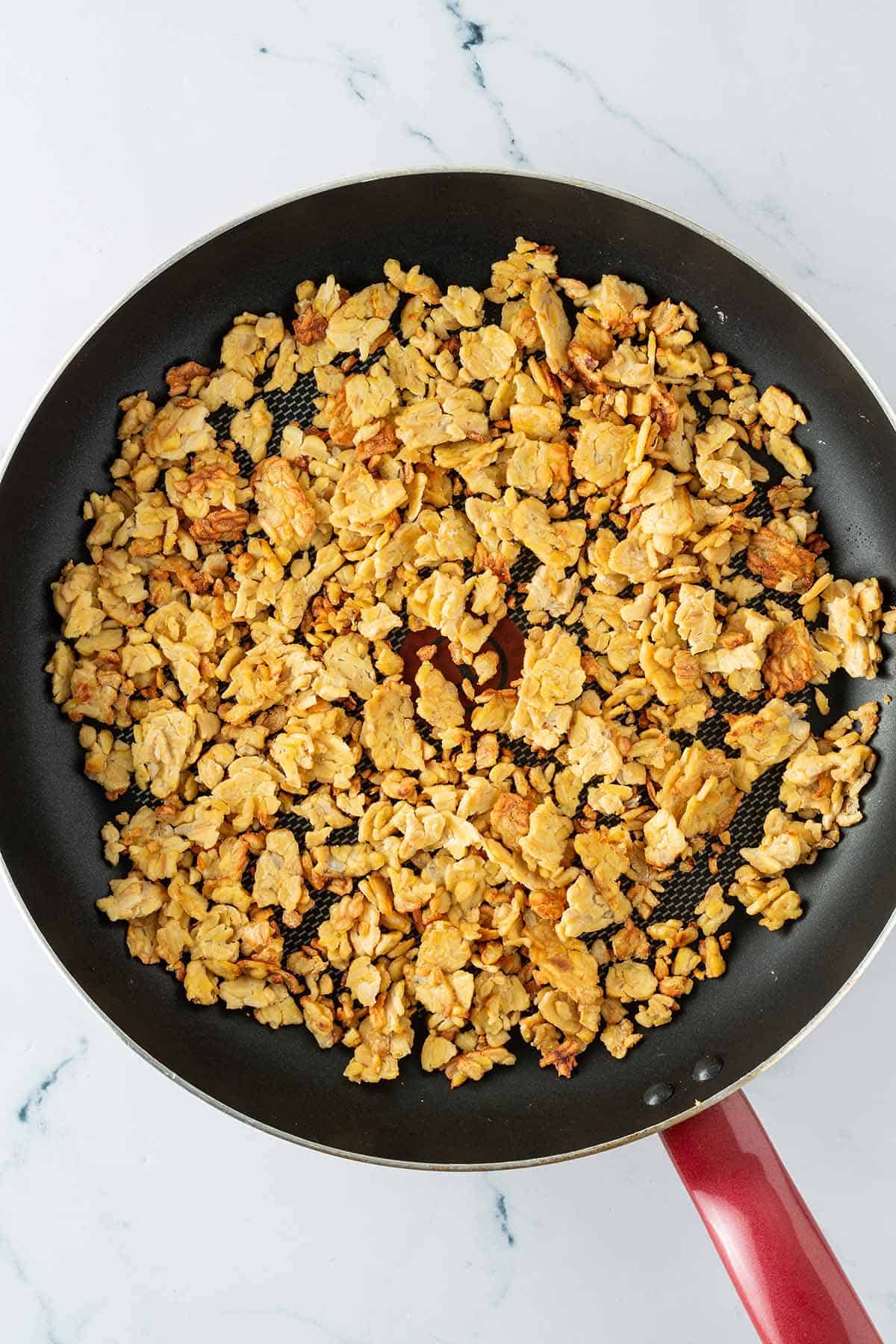 Knusprig angeratener Tempeh in einer Pfanne.