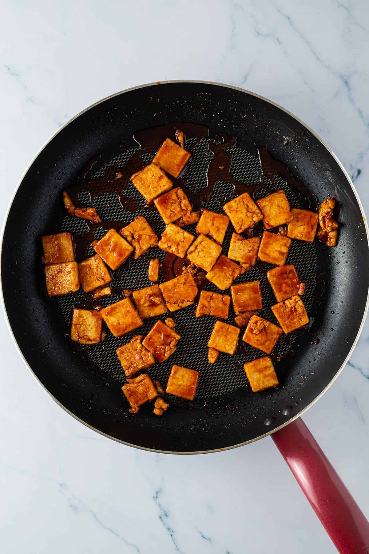 Knusprige Tofu-St&uuml;cke in der Pfanne mit der s&uuml;&szlig;-sauer-Sauce.