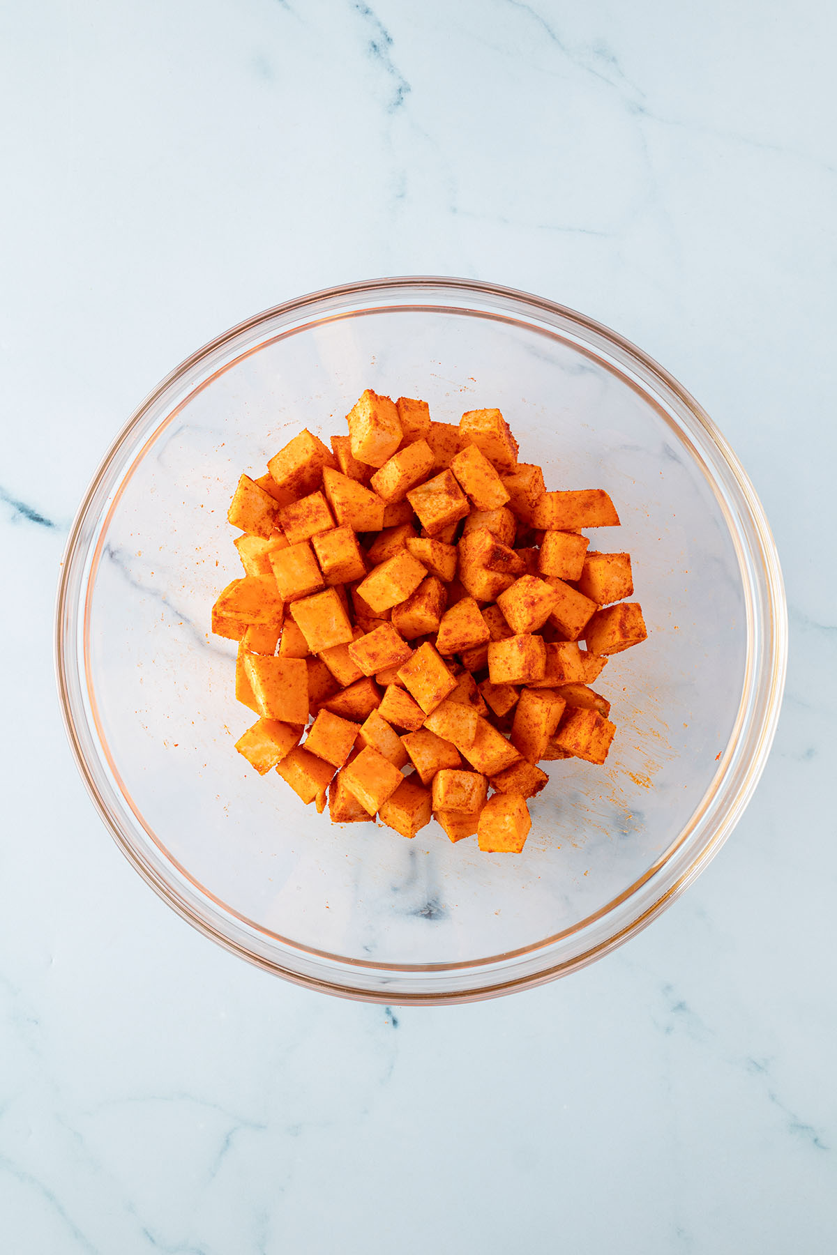 Mit Paprika gew&uuml;rzte S&uuml;&szlig;kartoffelecken in einer gro&szlig;en Glassch&uuml;ssel.