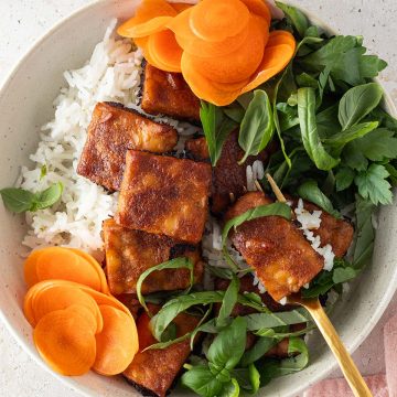 Tempeh Bowl mit frischen Kr&auml;utern, Reis, Karotten und knusprigen Erdnuss-Tempeh.