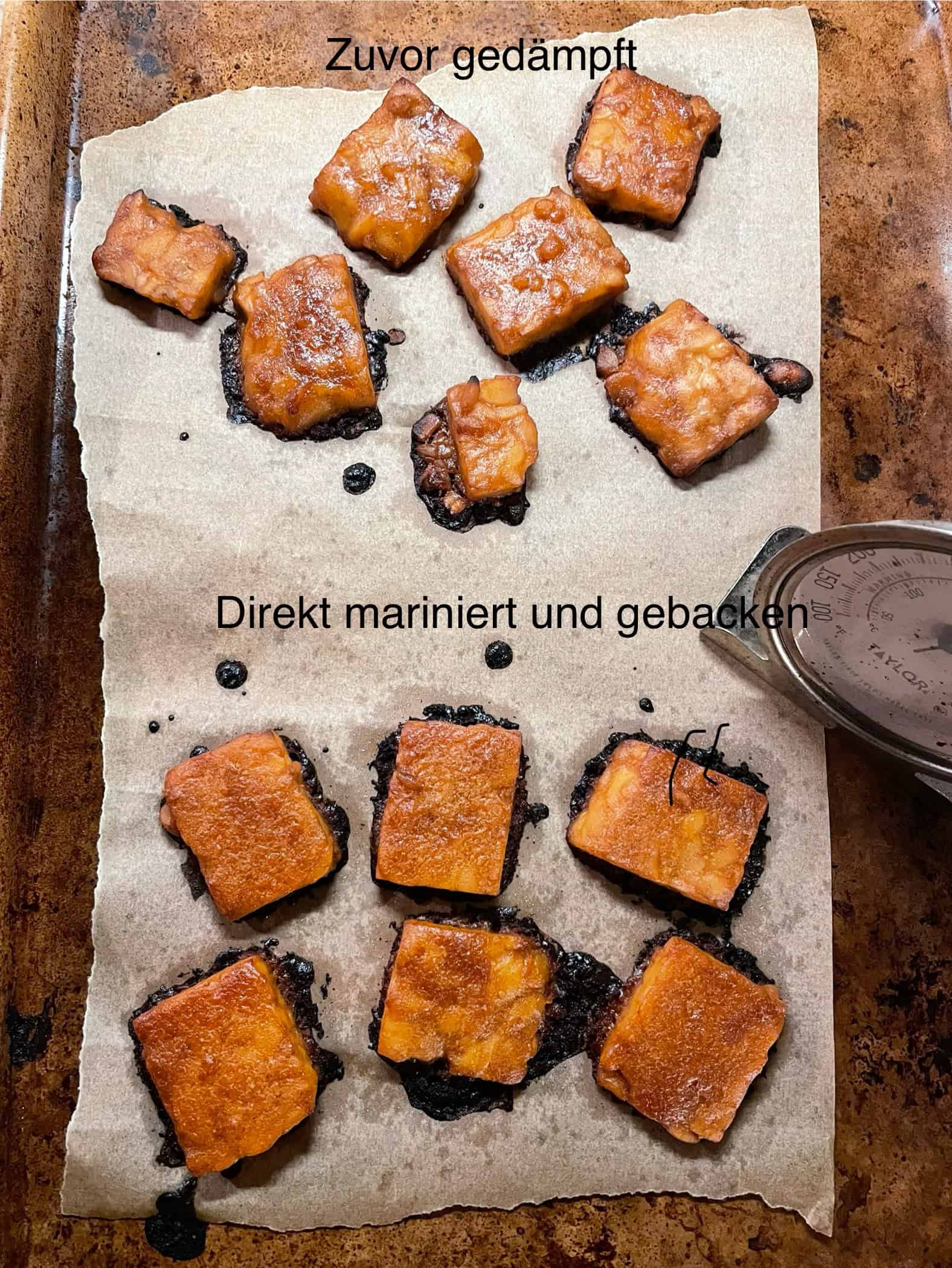 Im Ofen gebackene Tempeh Scheiben auf einem Blech, die H&auml;lfte wurde zuvor noch ged&auml;mpft.