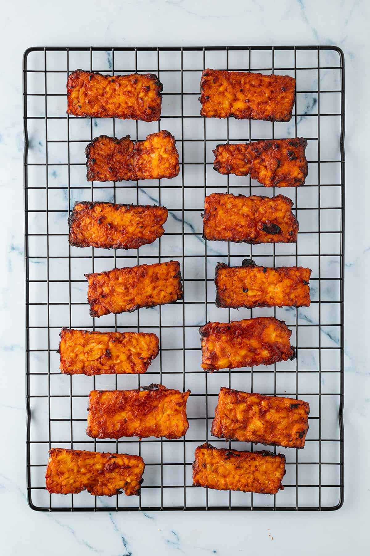 Im Aifryer zubereitete BBQ Tempeh Scheiben auf einem Ausk&uuml;hlrost.