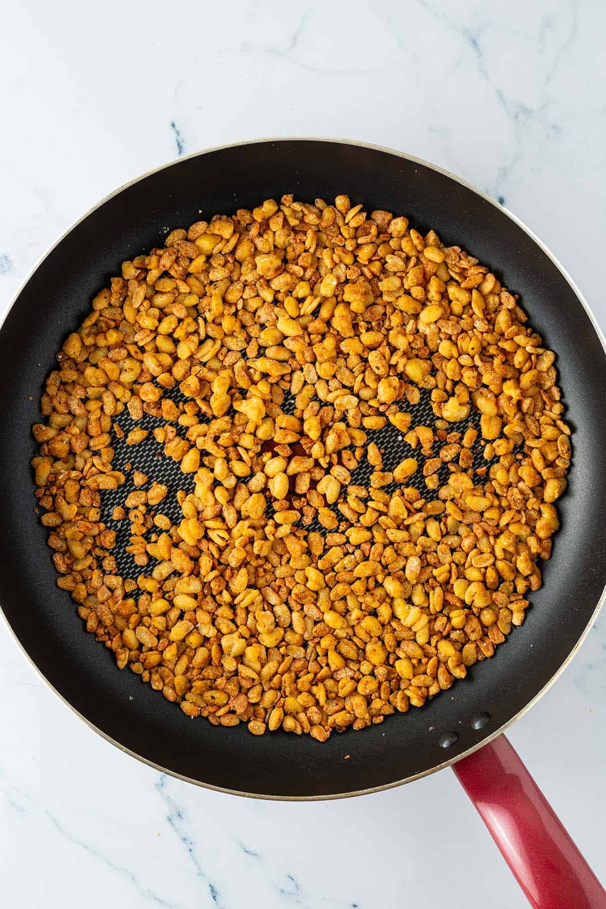 Knusprig angebratenes Tempeh Hack in einer Pfanne.