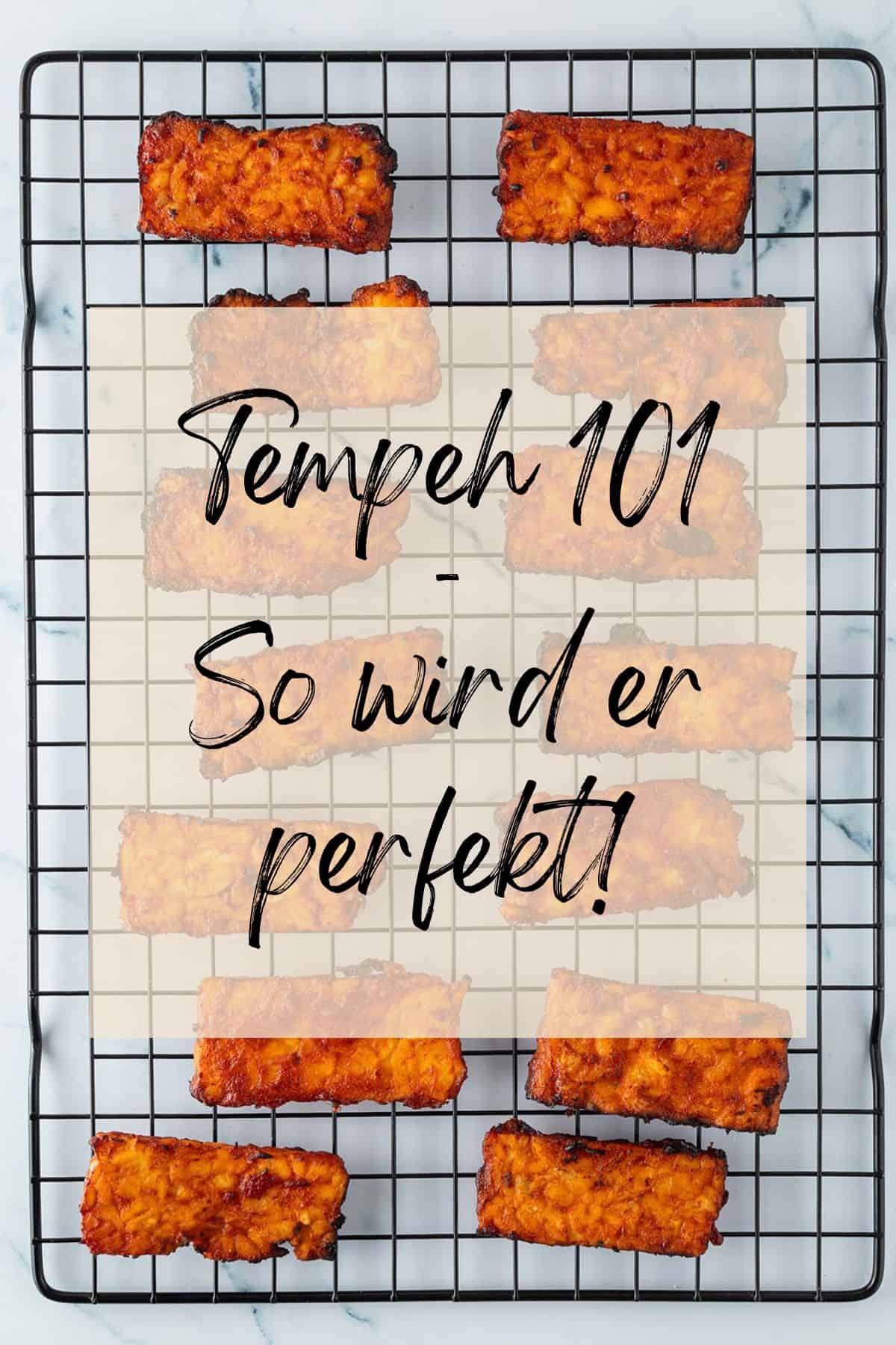 Knusprig gebratene Tempeh-Streifen auf einem Gitterrost, von oben fotografiert, mit Textoverlay &bdquo;Tempeh 101 &ndash; So wird er perfekt!&ldquo;.