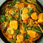 Thail&auml;ndisches Curry mit Frischst&uuml;ckchen, Gem&uuml;se und einer cremigen Sauce wird serviert mit frischen Kr&auml;utern.