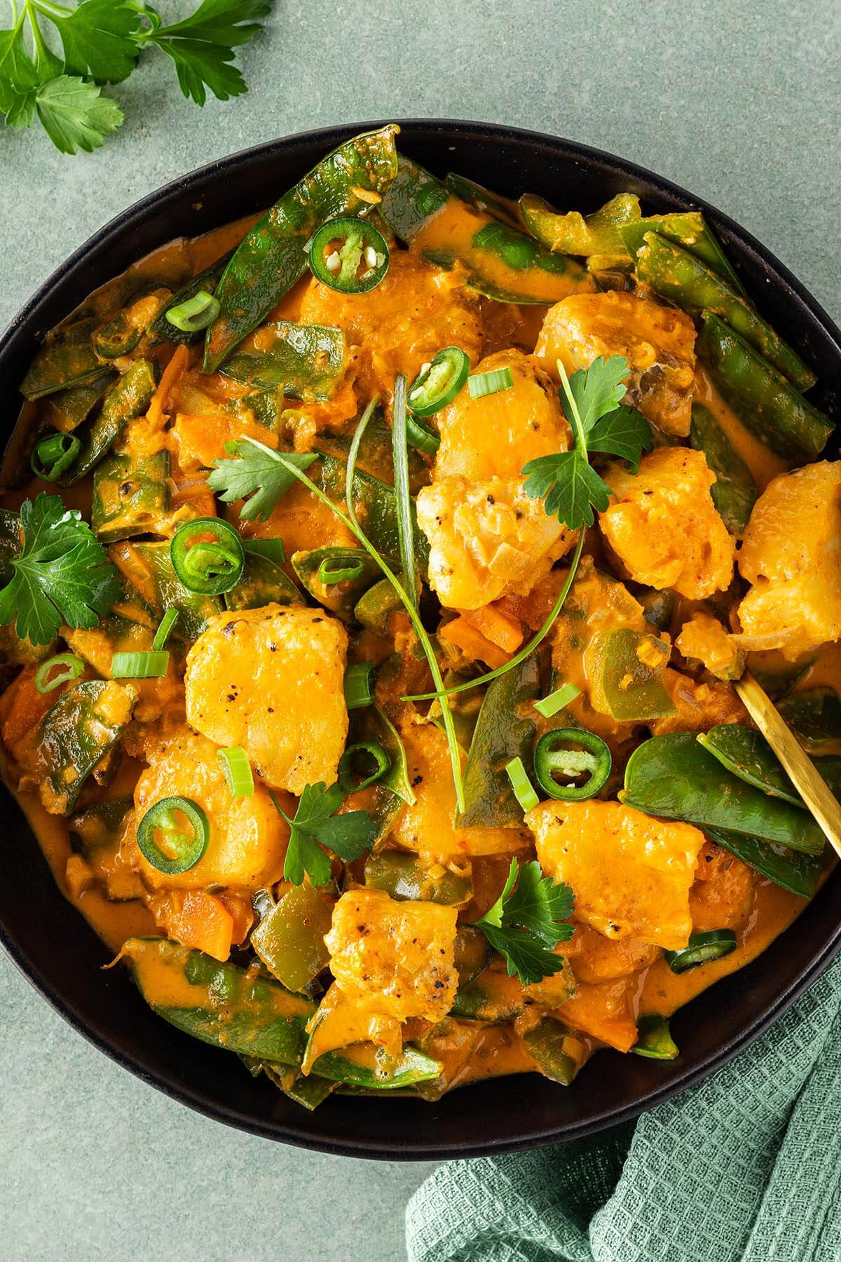 Thail&auml;ndisches Curry mit Frischst&uuml;ckchen, Gem&uuml;se und einer cremigen Sauce wird serviert mit frischen Kr&auml;utern.
