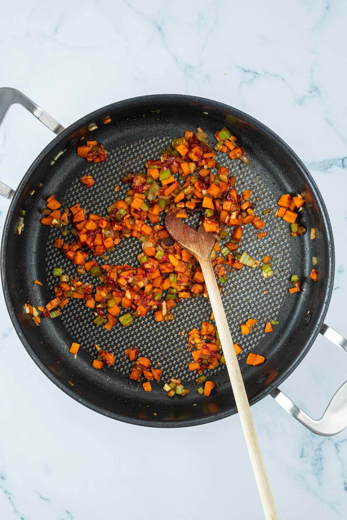 Angebratenes Gem&uuml;se mit Tomatenmark in einer Pfanne.