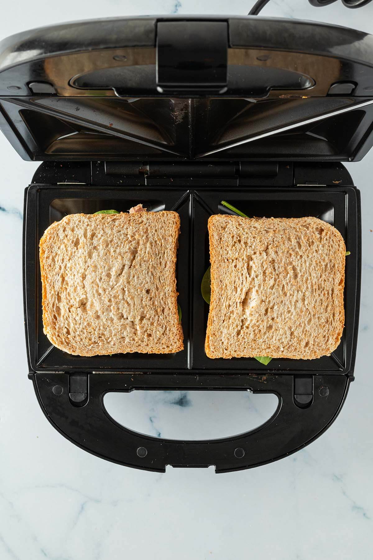 Vogelperspektive auf einen Sandwichmaker mit zwei Sandwiches.