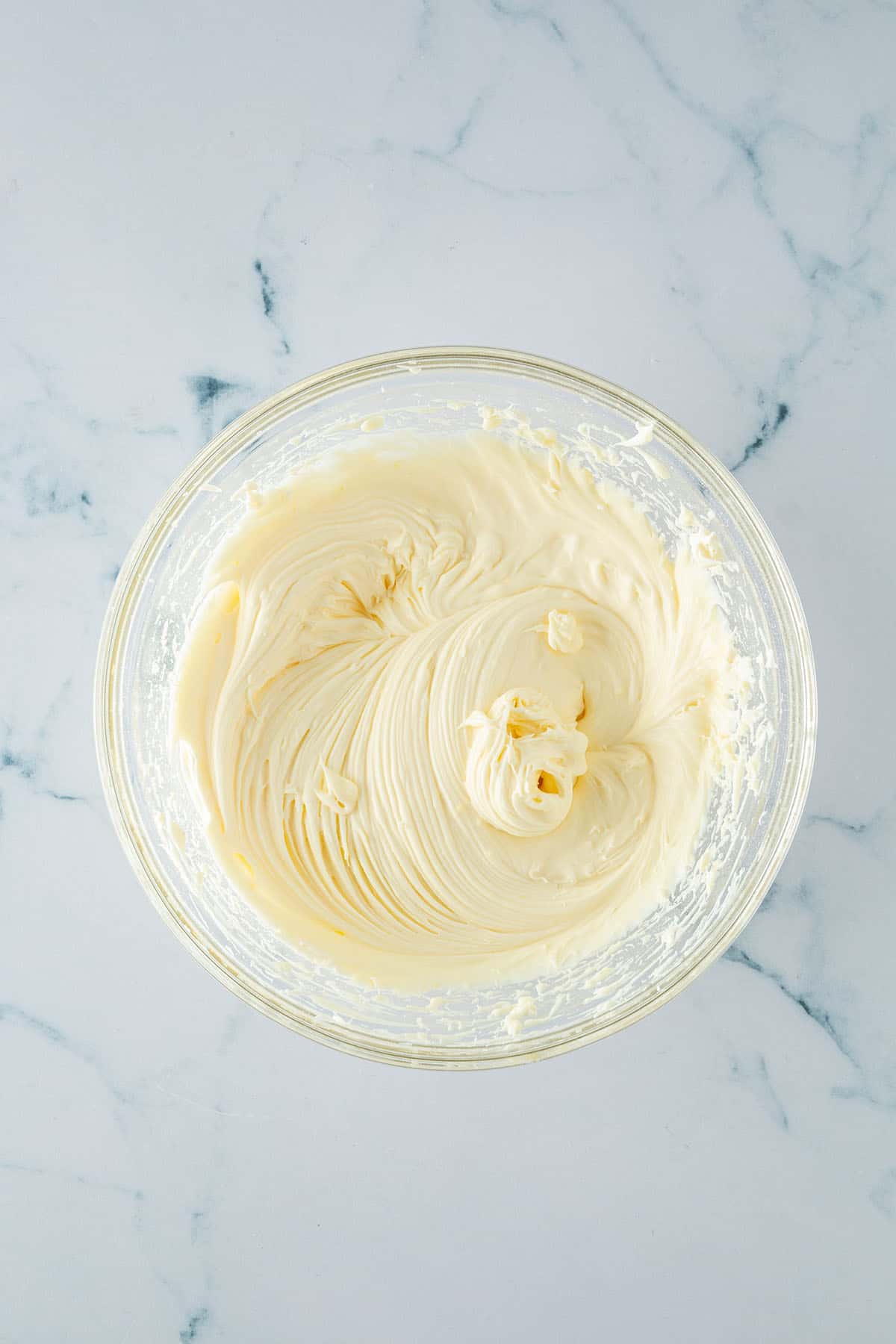 Cremig aufgeschlagene Mascarponecreme in einer Glassch&uuml;ssel von oben.