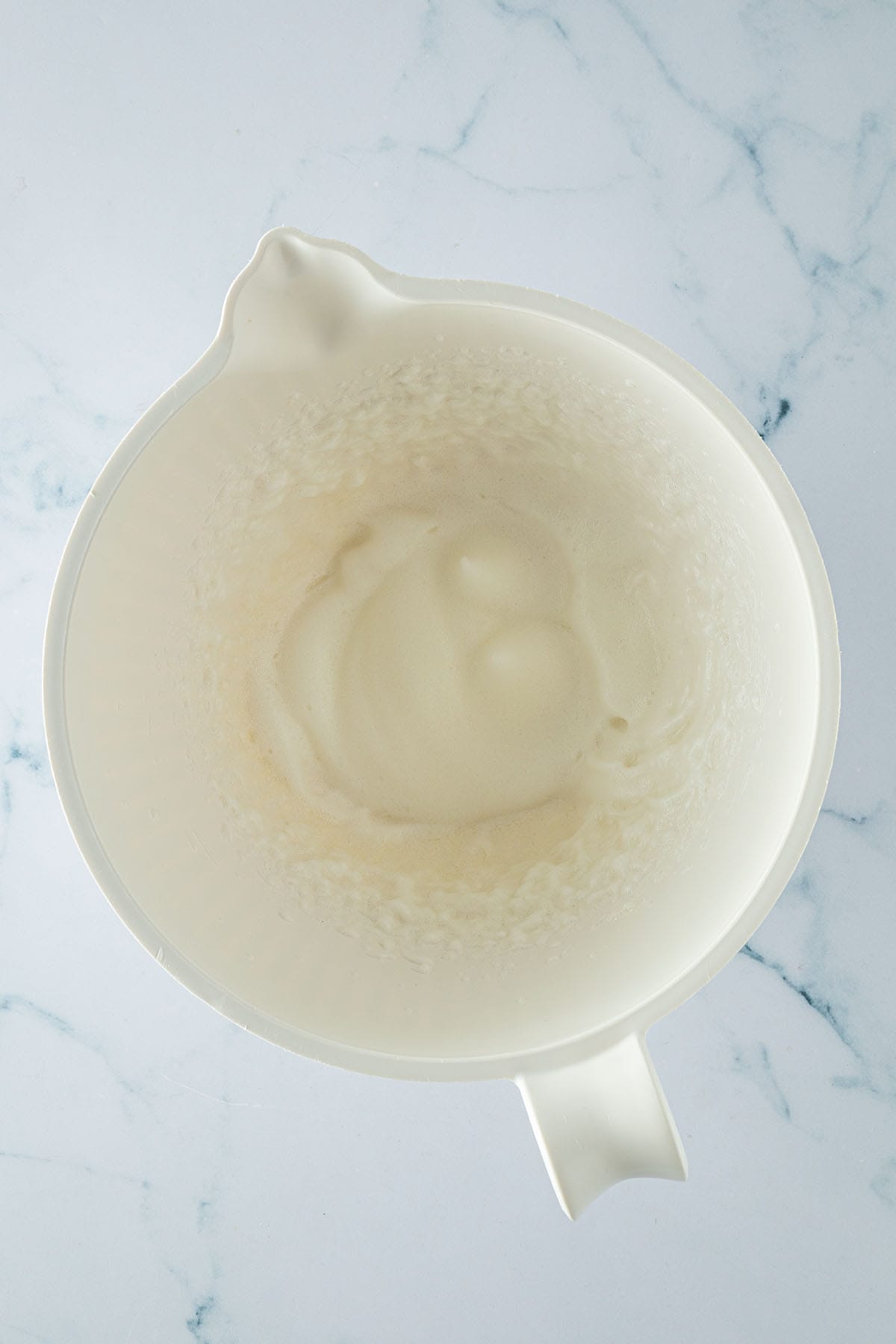 Steif geschlagener Eischnee in einer wei&szlig;en R&uuml;hrsch&uuml;ssel.