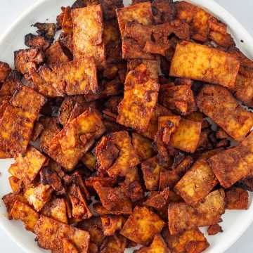 Knusprig gebackene Tofu-Gyros-Streifen auf einem wei&szlig;en Teller.