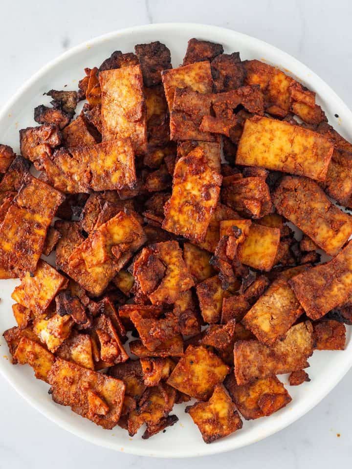 Knusprig gebackene Tofu-Gyros-Streifen auf einem wei&szlig;en Teller.