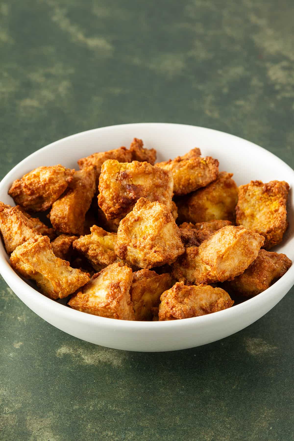 Knusprige, marinierte Tofuw&uuml;rfel aus dem Airfryer in einer wei&szlig;en Sch&uuml;ssel.
