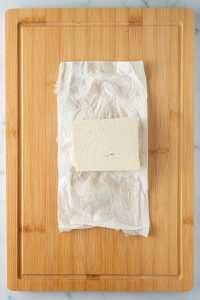 Ein Block Tofu wurde auf etwas K&uuml;chenrolle ausgepresst.