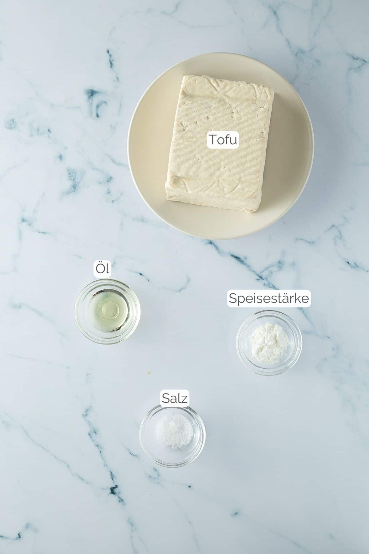 Alle Zutaten mit Textbeschriftungen, die f&uuml;r knusprigen Tofu aus der Hei&szlig;luftfritteuse ben&ouml;tigt werden.