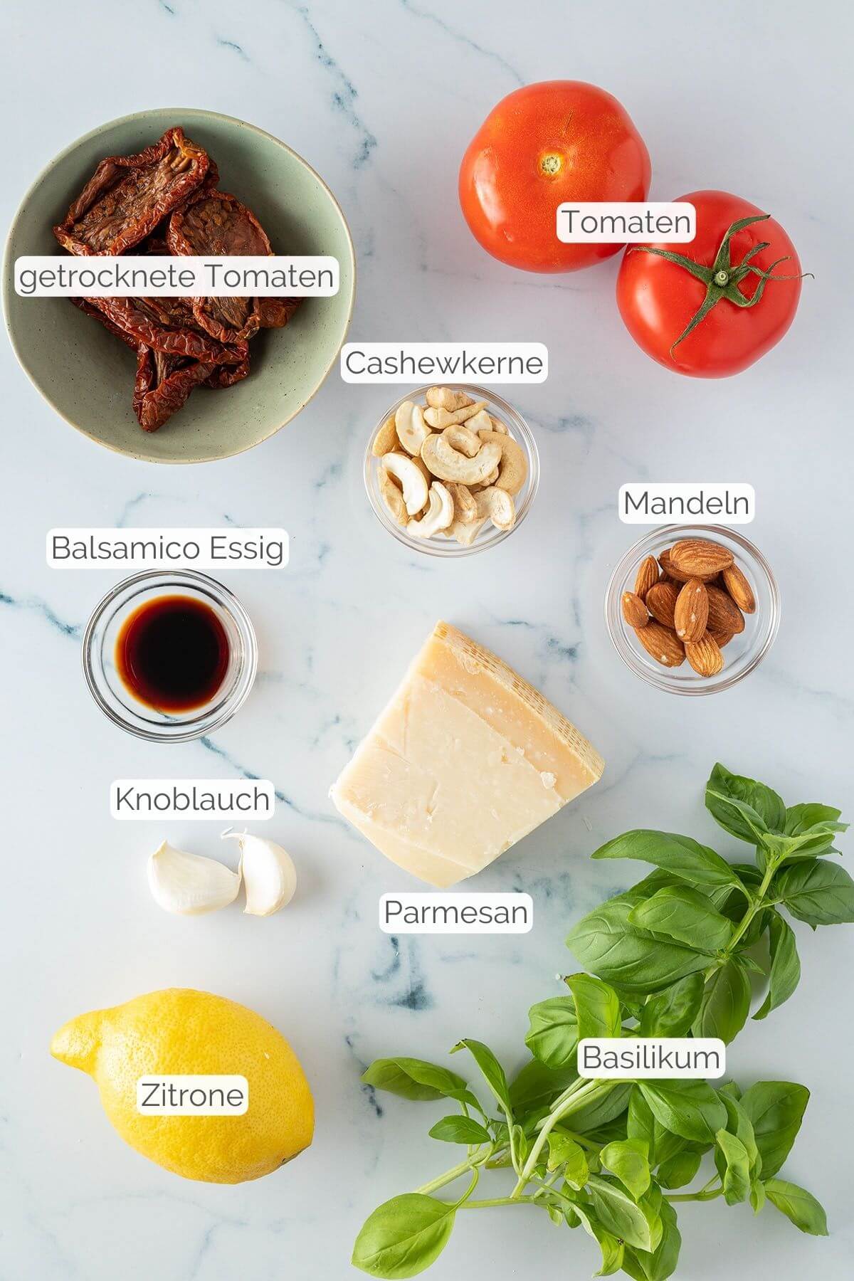 Foto aller Zutaten mit jeweiligen Textbeschriftungen, die f&uuml;r die Tomatenpesto ben&ouml;tigt werden.