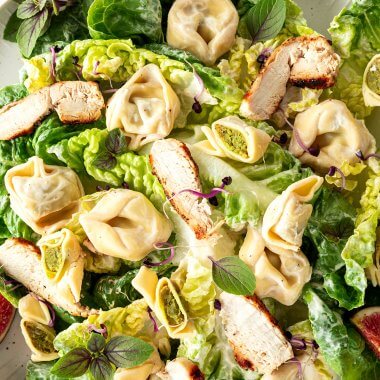 Tortellini Salat mit einem cremigen Dressing ohne Mayo serviert mit frischem Salat und saftigen Hähnchenstreifen.
