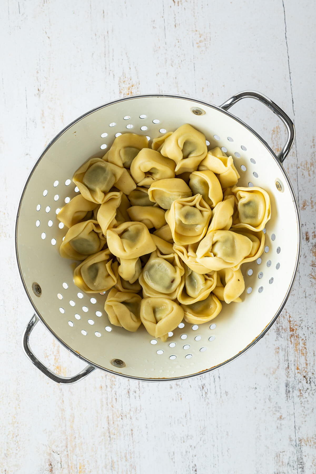 Gekochte Tortellini in einem Seiher.