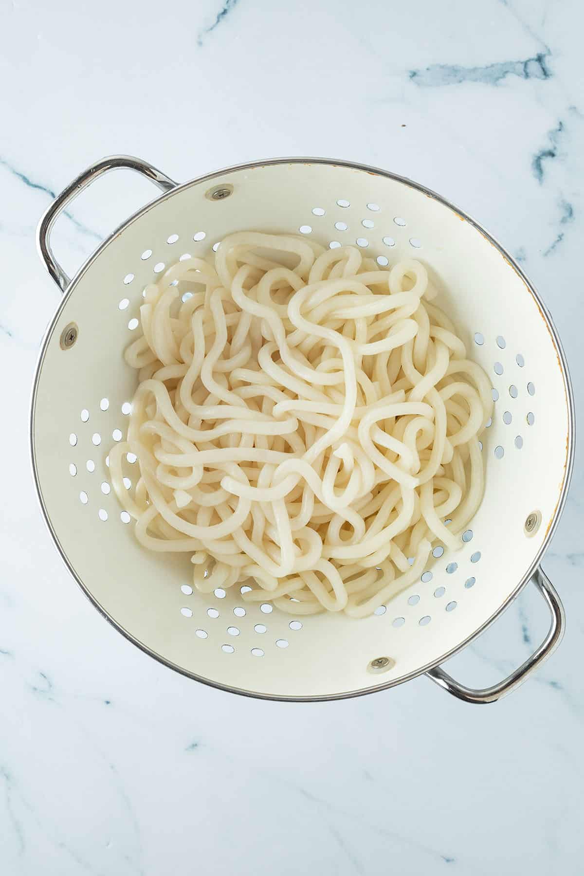 Gekochte Udon Nudeln in einem Seiher.