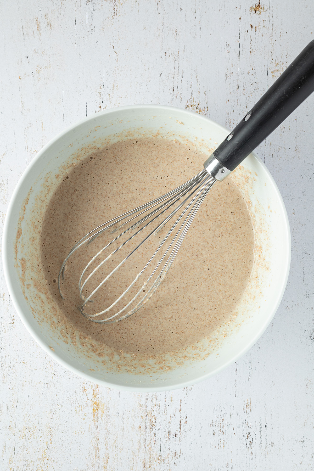 Pfannkuchenteig f&uuml;r die veganen Pancakes in einer gro&szlig;en Sch&uuml;ssel mit einem Schneebesen