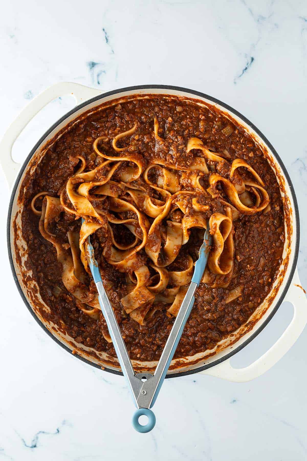 Gekochte Nudeln werden in die fertige Bolognese Sauce einger&uuml;hrt.