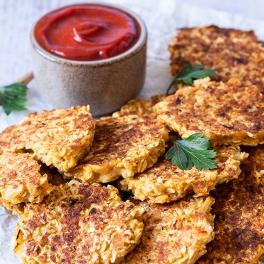 Vegetarische Frikadellen aus Haferflocken serviert mit Ketchup.