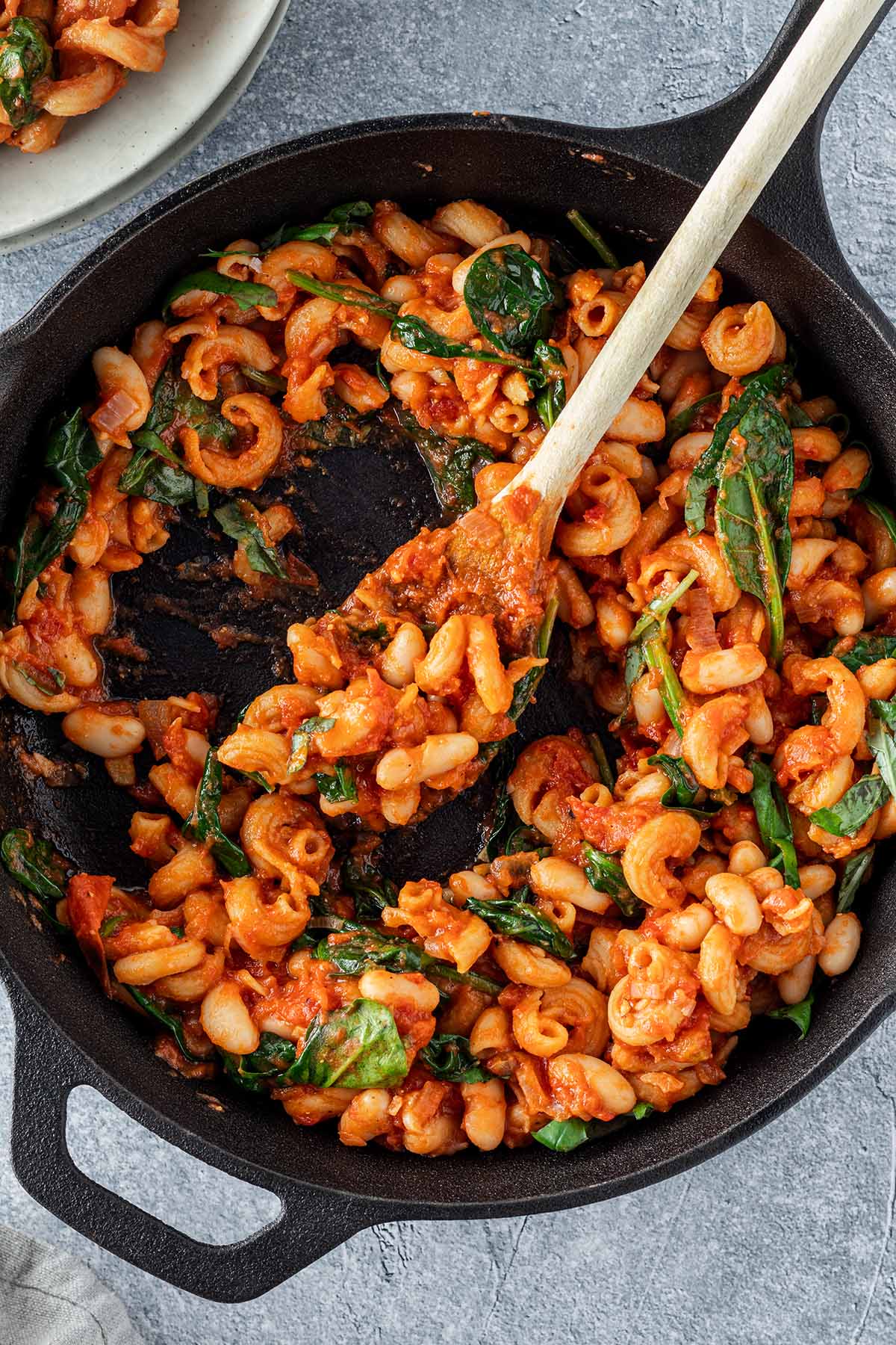 Vogelperspektive auf eine Gusseisenpfanne, aus der gerade eine Portion der One Pot Pasta entnommen wird.