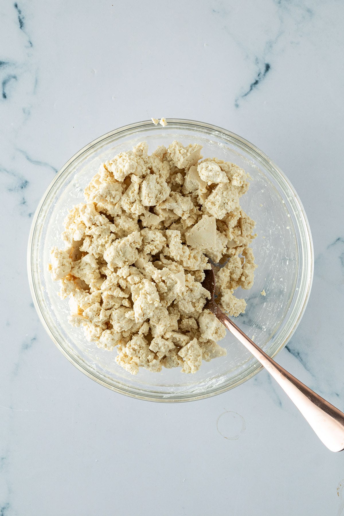 Zerbr&ouml;selter Naturtofu in einer Glassch&uuml;ssel mit Speisest&auml;rke verr&uuml;hrt.