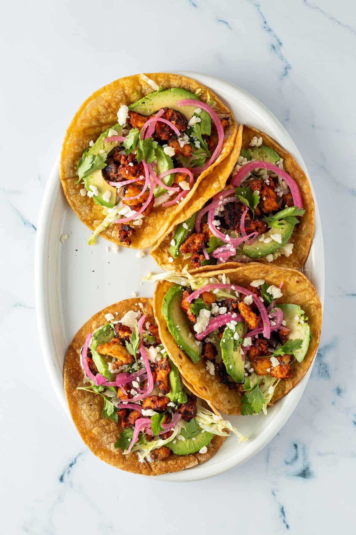 Fertig gef&uuml;llte Tacos mit Pickled Onions und K&auml;se.