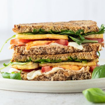 Tofu Sandwich mit Tomate und Mozzarella vor wei&szlig;em Hintergrund.
