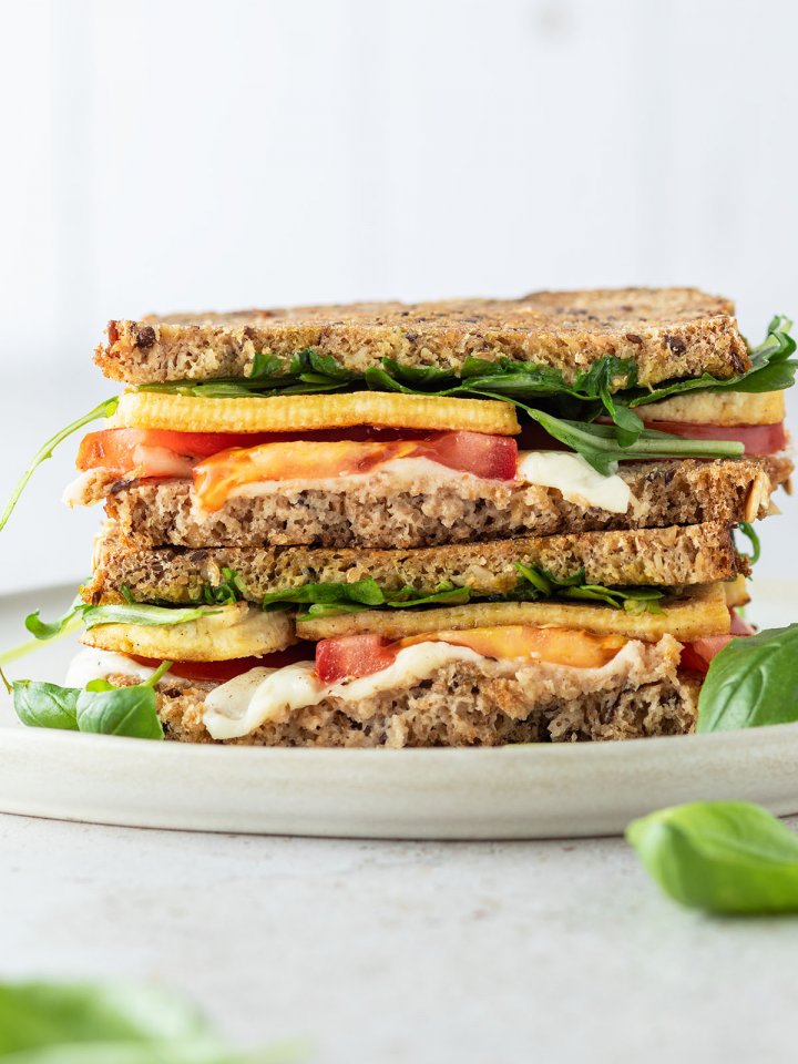 Tofu Sandwich mit Tomate und Mozzarella vor wei&szlig;em Hintergrund.