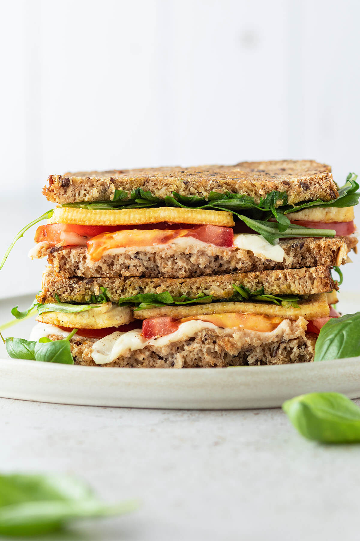 Tofu Sandwich mit Tomate und Mozzarella vor wei&szlig;em Hintergrund.