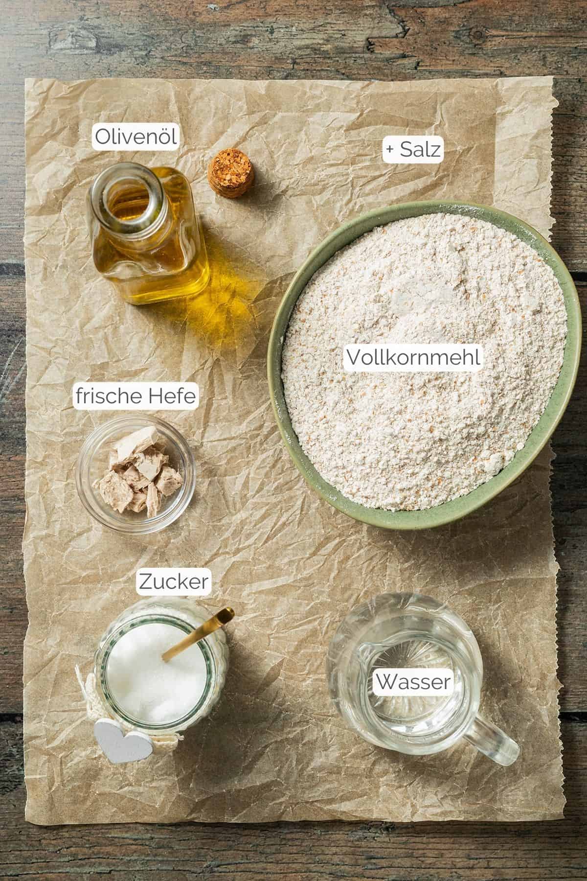 Alle Zutaten mit jeweiligen Textbeschriftungen, die du für einen gesunden Vollkorn Pizzateig benötigst.