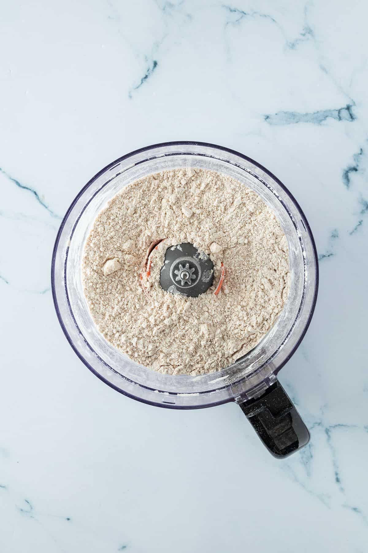 Vollkornmehl und fein zerkleinerte Butter in einem Food Processor.