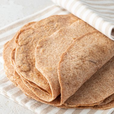 Ein Stapel aus Vollkorn Wraps ein einem Geschirrtuch.