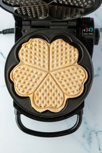 Vogelperspektive auf eine ausgebackene Waffel, in einem ge&ouml;ffneten Waffeleisen.