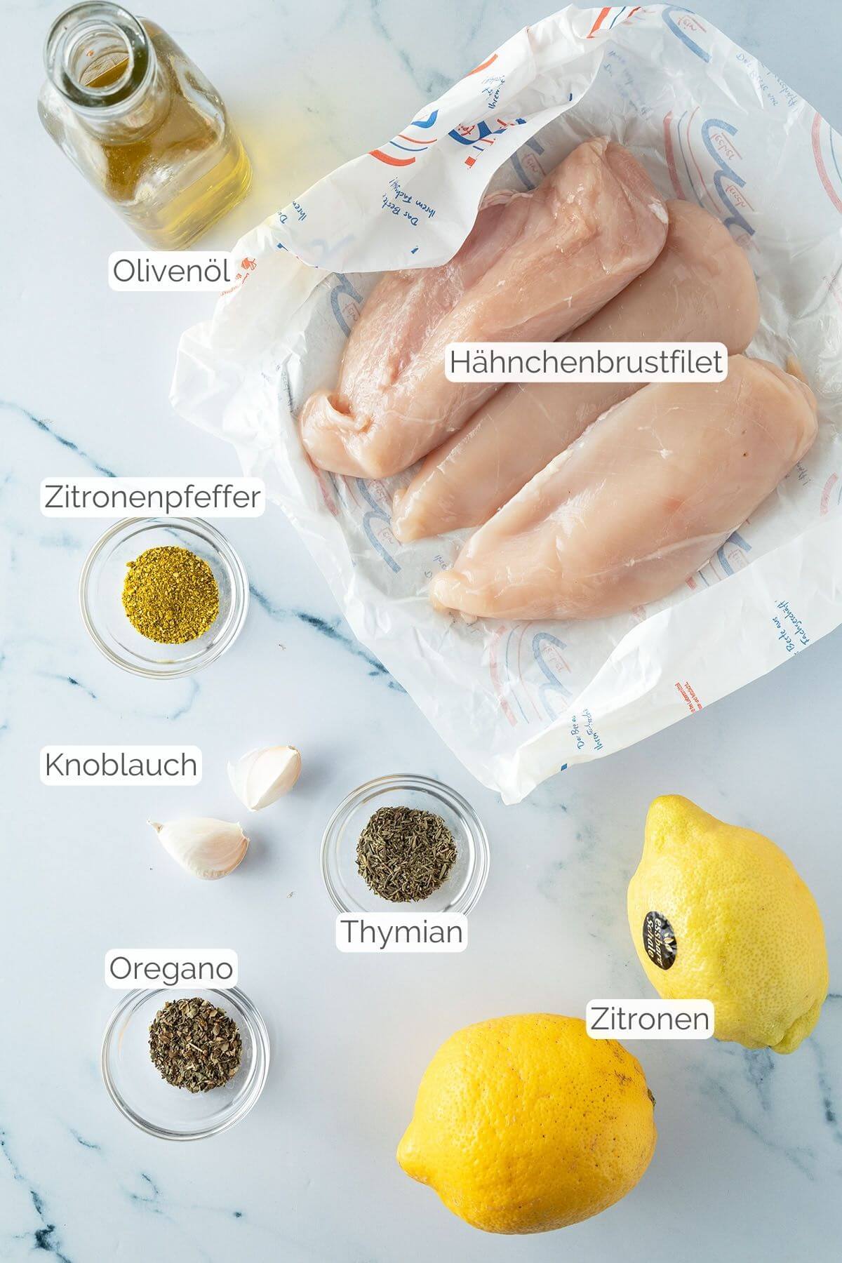 Foto aller Zutaten mit jeweiligen Textbeschriftungen, die f&uuml;r Zitronen-H&auml;hnchenbrustfilets aus dem Ofen ben&ouml;tigt werden.