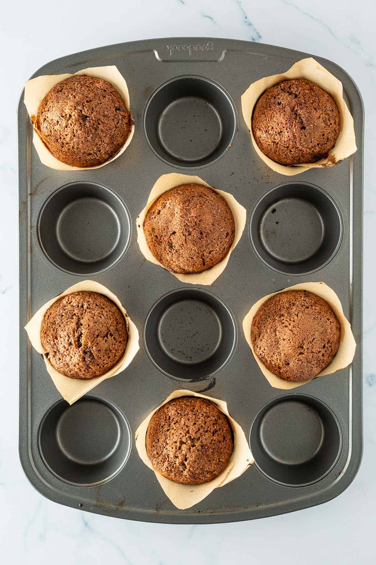 Frisch gebackene Schoko Zucchini Muffins im Muffinblech mit Backpapierf&ouml;rmchen.