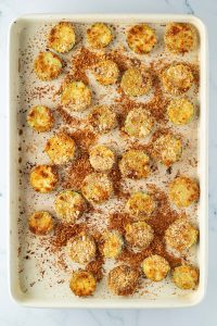 Goldbraun gebackene Parmesan Zucchini Chips auf einem Blech.