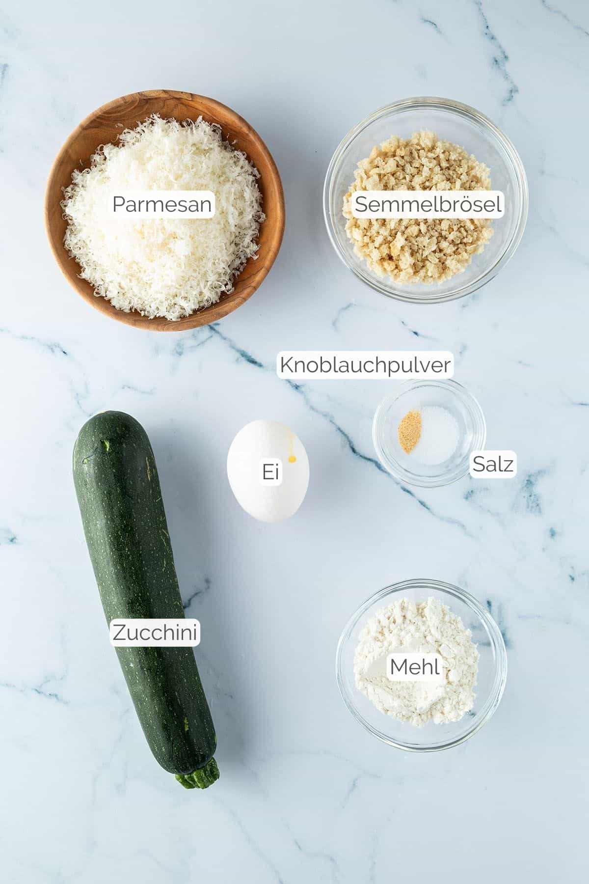Alle Zutaten mit Textbeschriftungen, die f&uuml;r Zucchini Parmesan Chips ben&ouml;tigt werden.