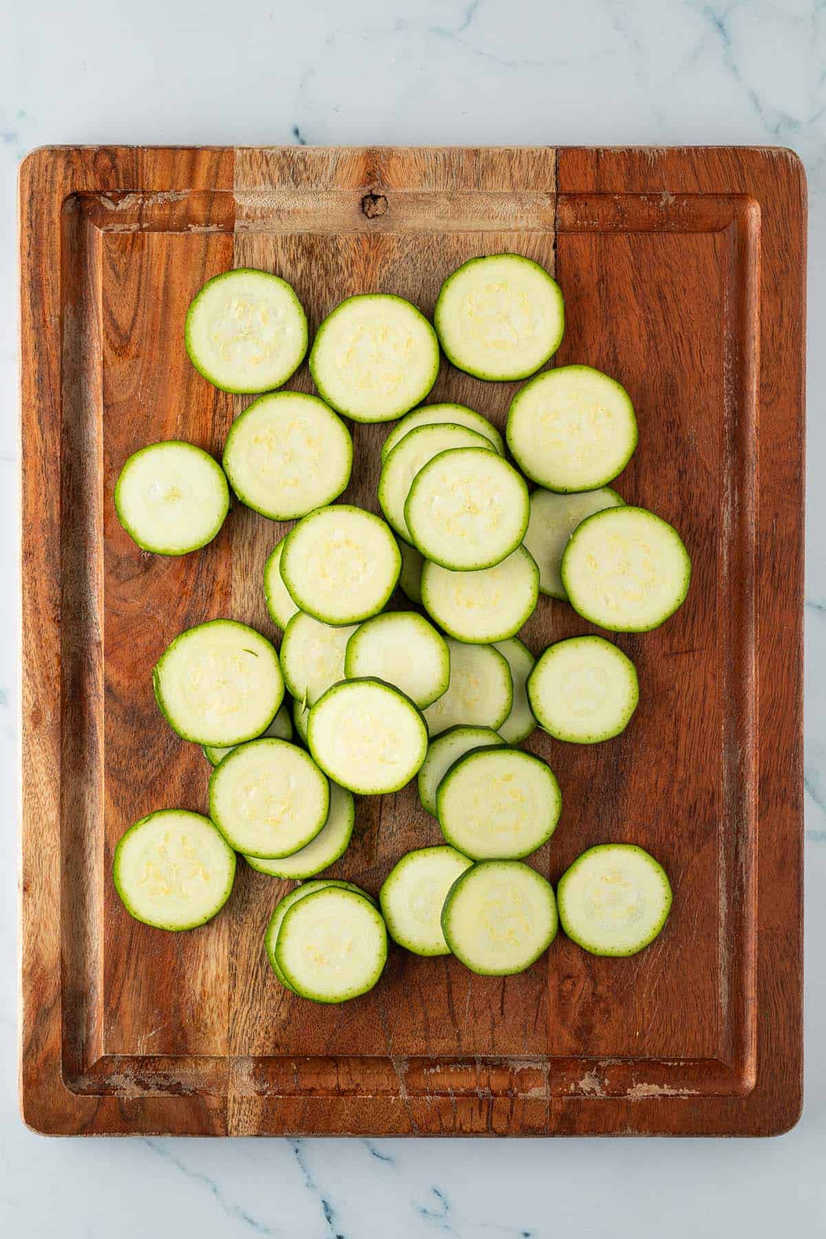 In Scheiben geschnittene Zucchini auf einem Holzbrett.