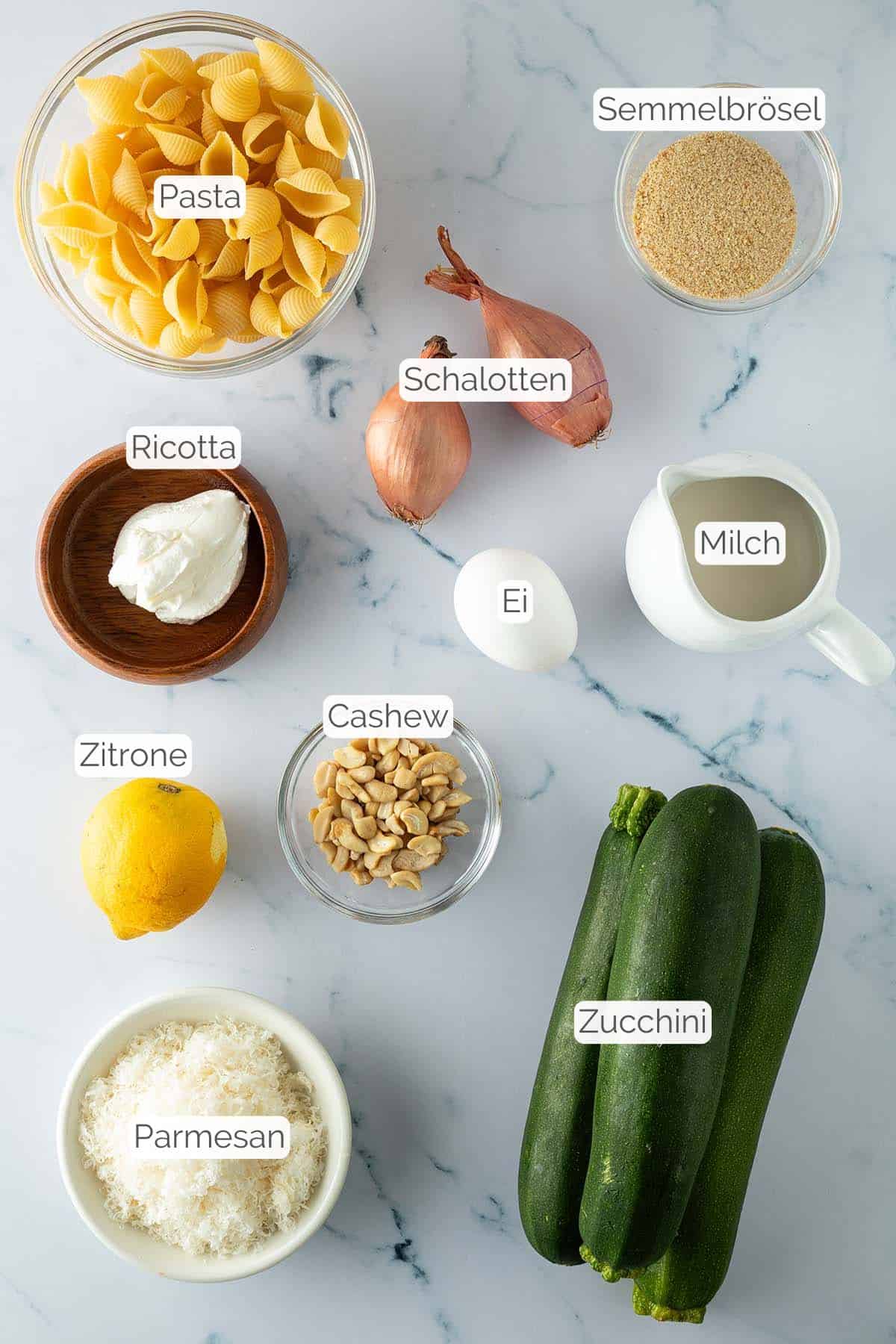 Alle Zutaten mit jeweiligen Textbeschriftungen, die f&uuml;r die Zucchini Pasta ben&ouml;tigt werden.
